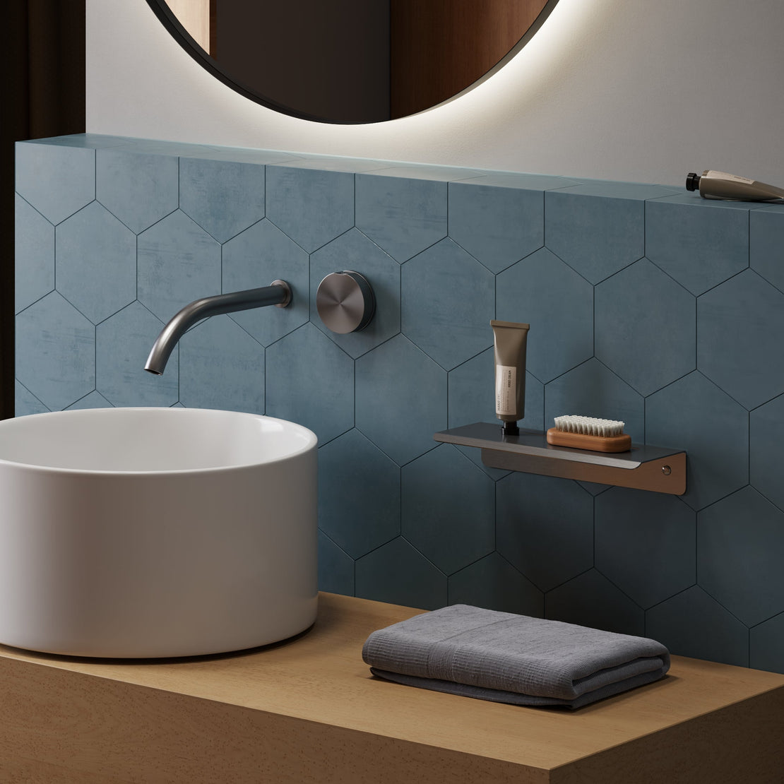 Bathroom setup with a white sink, towel, and toiletries against a blue tiled wall.