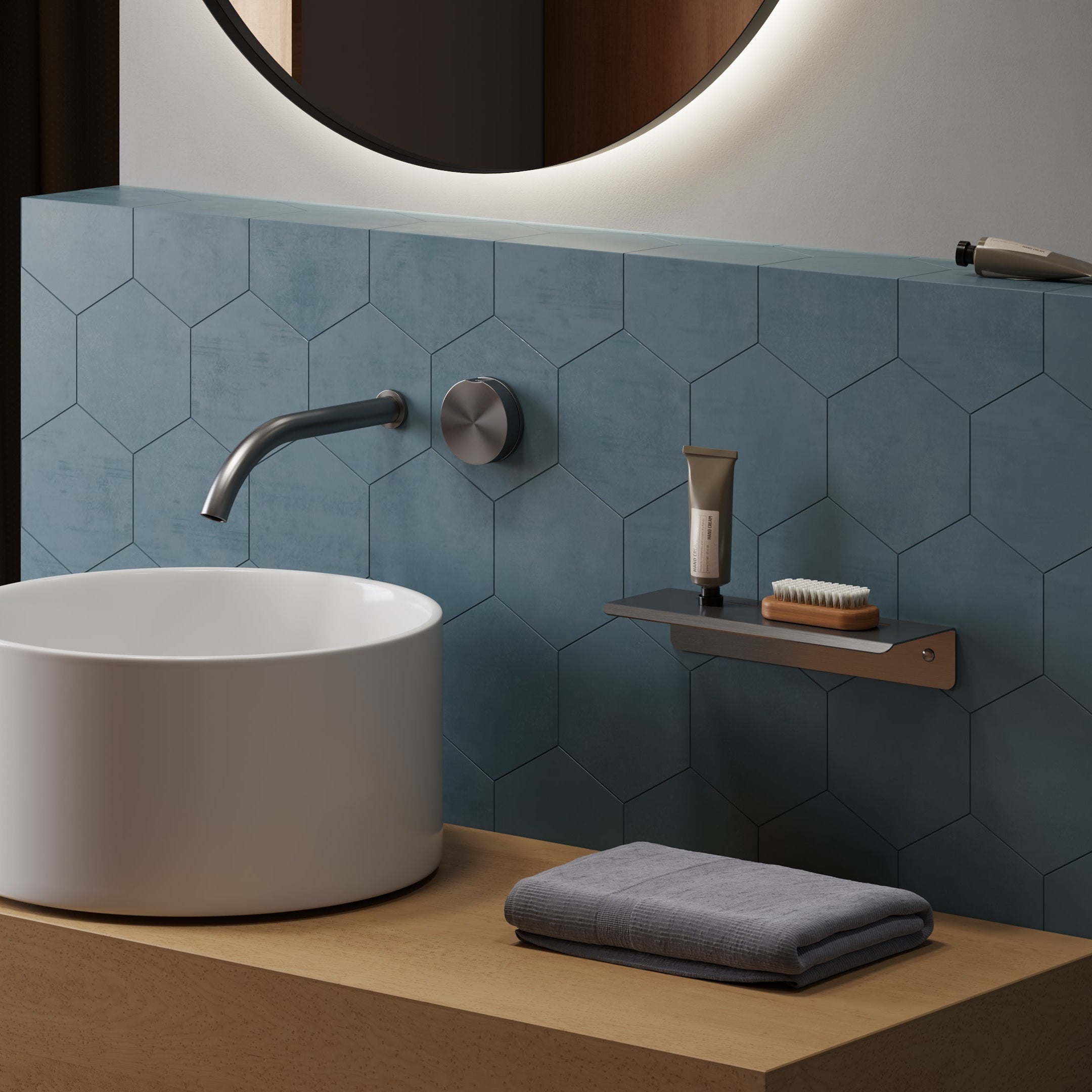 Bathroom setup with a white sink, towel, and toiletries against a blue tiled wall.