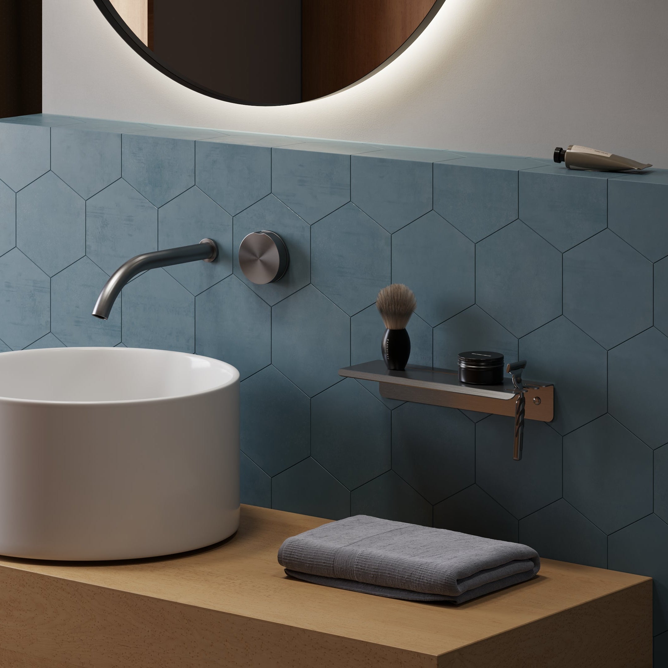Bathroom setup with a white sink, faucet, and towel on a wooden counter against a blue tiled wall. Chrome steel shelf on the wall