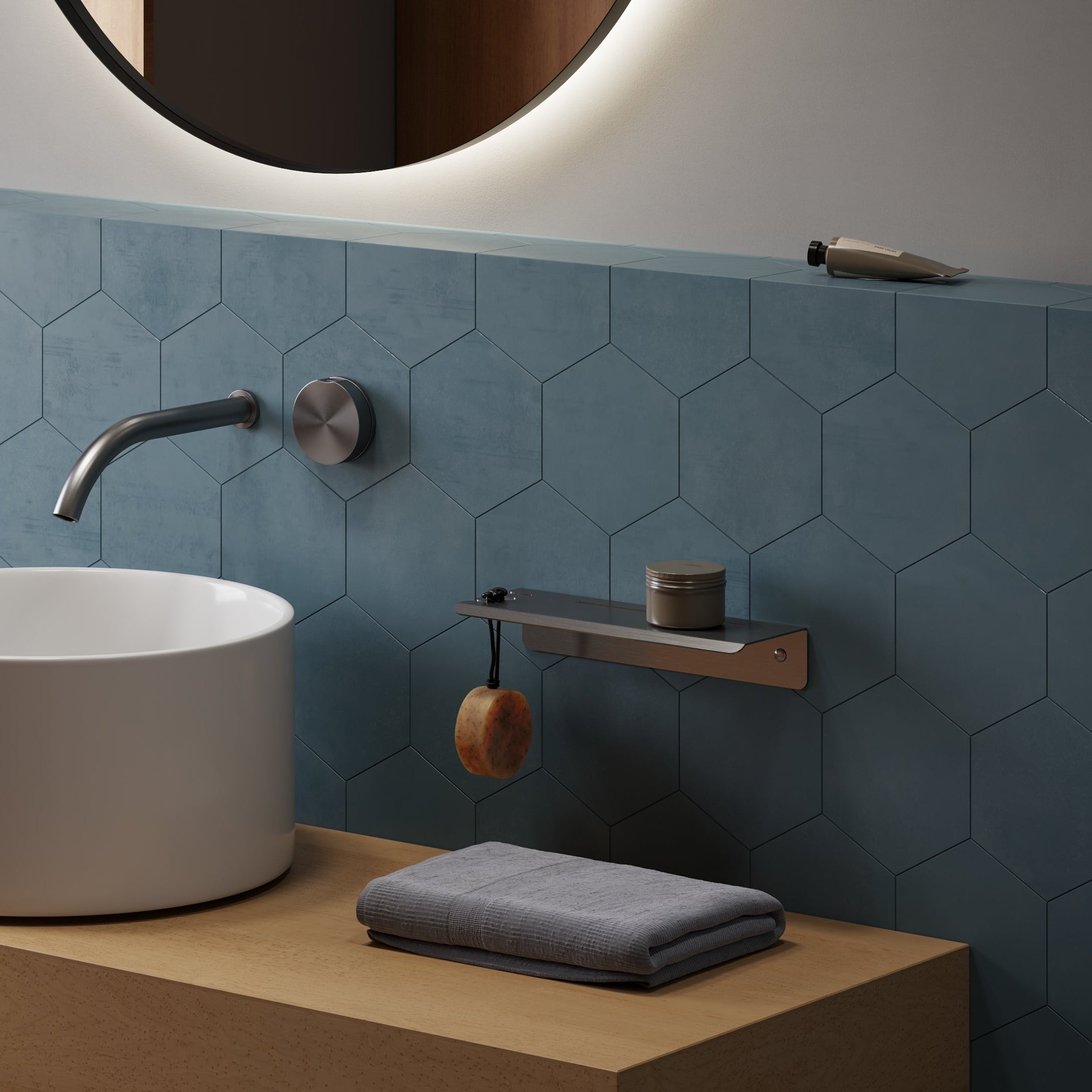 Bathroom setting with a white sink, faucet, and blue tiled wall. Steel Sink shelf on the wall