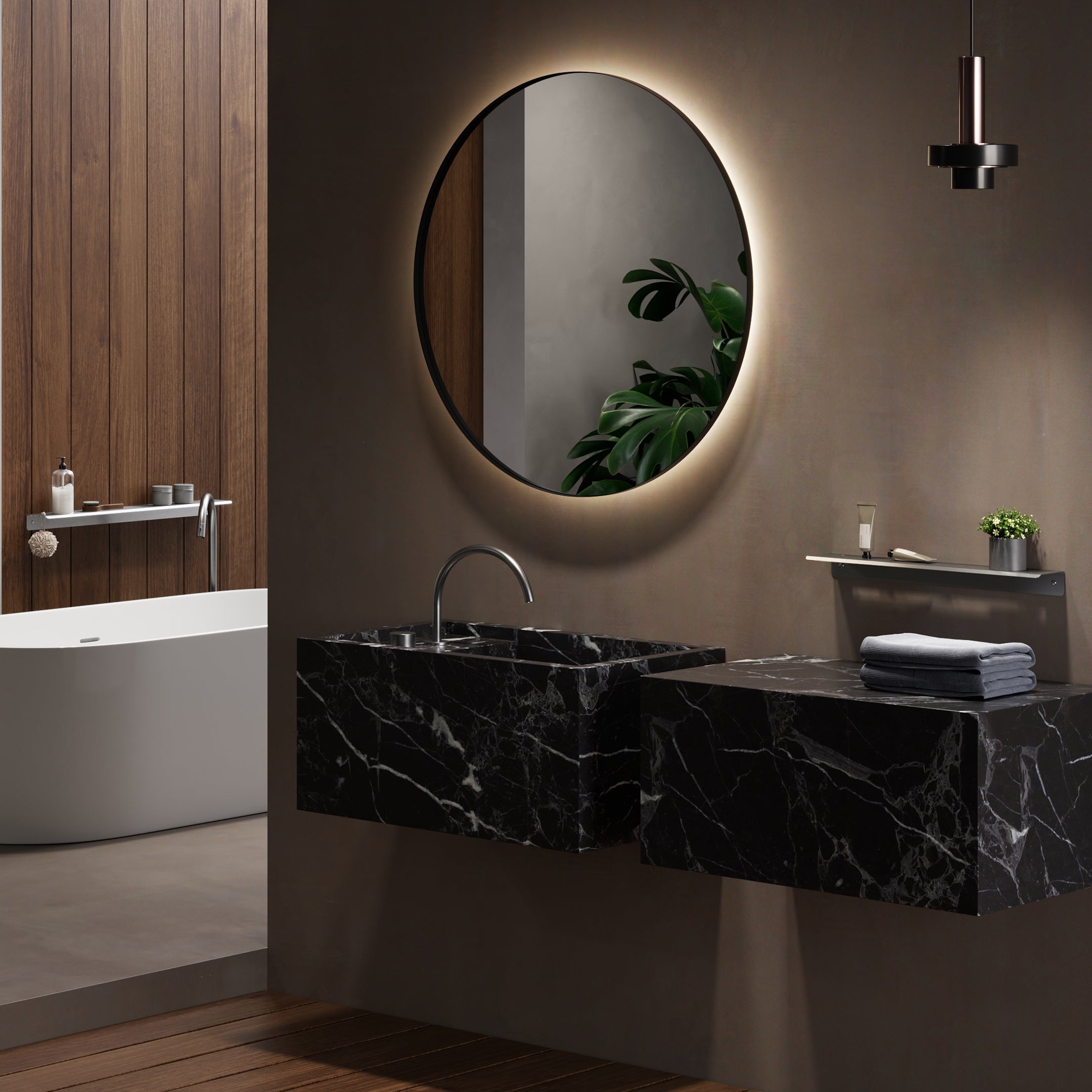 Modern bathroom with freestanding bathtub, toilet, and black marble vanity.