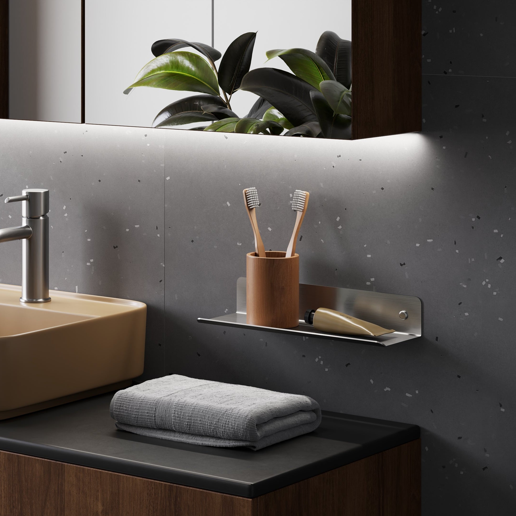 Bathroom vanity with beige sink, faucet, and towel on a dark countertop.